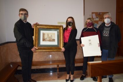 La primera edil hace entrega al párroco del Santuario Nuestra Señora del Pilar del grabado número 1 de un total de 25./TCVB El Ayuntamiento solicitará la declaración de la romería en honor a la Virgen del Pilar como Fiesta de Interés Turístico Autonómico